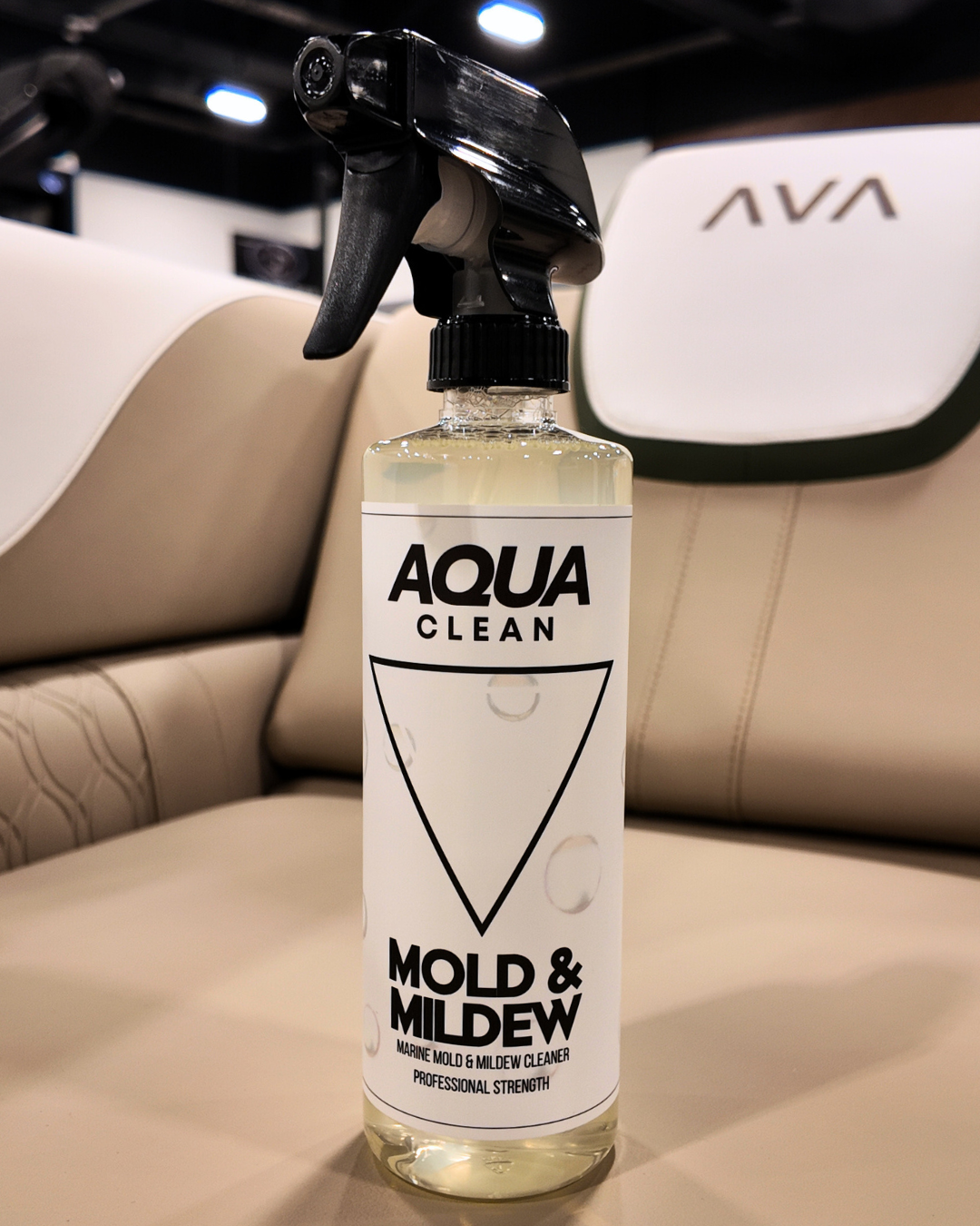 AquaClean Mold and Mildew cleaner spray bottle on tan leather car seat with AVA branding in background